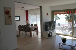 a living room with a dining table and a television at le chantilly in Cagnes-sur-Mer