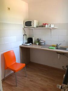 a kitchen with an orange chair and a sink at Rana's Zimmervermittlung 2 in Bremen