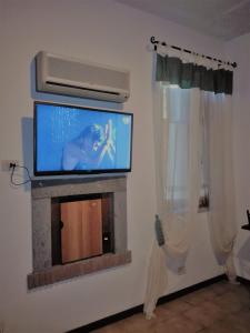 sala de estar con TV y chimenea en B&B La Quercia, en Orte