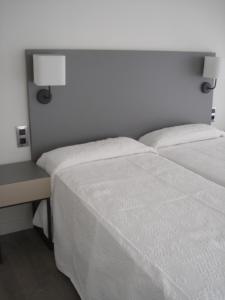 フエンヒロラにあるStella Maris - Fuengirolaのベッドルーム(白いベッド1台、ランプ付きデスク付)