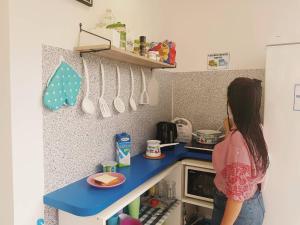 a woman is standing in a small kitchen at Hostel Petra Marina in Dubrovnik
