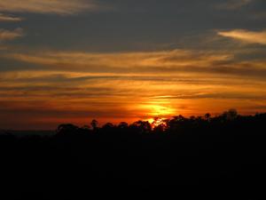 a sunset with the sun setting in the background at Poente Guest House in Conceição da Ibitipoca