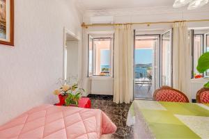 a bedroom with a bed and a table and a balcony at Veranda Syros House in Ermoupoli +75 photos