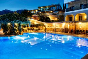 a swimming pool in front of a hotel at night at Miramare in Eretria