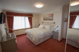 a bedroom with a bed and two windows at GOLFVIEW 4 in Buckie