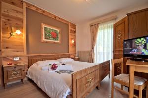 1 dormitorio con 1 cama y TV en una habitación en Hotel Garni Edy, en Daiano