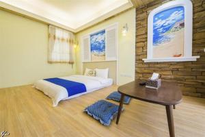 a bedroom with a bed and a table in it at Xin Ju in Taitung City