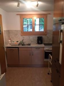 eine kleine Küche mit einem Waschbecken und einem Fenster in der Unterkunft Chalet Gärlich in Bürchen