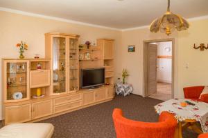 a living room with a television and wooden cabinets at Haus Frieda in Ostseebad Koserow