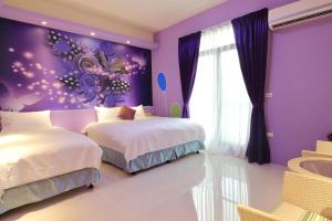 Dormitorio púrpura con 2 camas y ventana en Sunshine B&B en Hualien