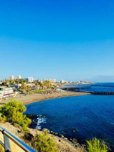 a view of a beach and the ocean at Enjoy the sea and pool in Playa de las Americas in Playa de las Americas