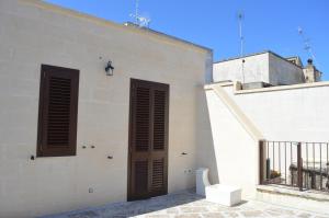 ein weißes Gebäude mit braunen Fensterläden darauf in der Unterkunft Nonna Concetta in Palmariggi