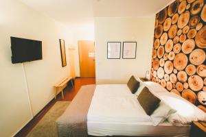 een slaapkamer met een bed en een muur van houtblokken bij Ostel Jugendhotel Bremervörde in Bremervörde