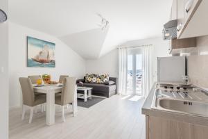 a kitchen and living room with a table and a couch at Apartments HIPERION in Zadar