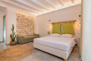 a white bedroom with a bed and a couch at Vintage Suites in Limenaria