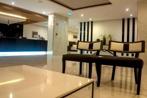a lobby with two chairs and a table in a building at Flor Da Rocha in Portimão