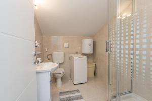 a bathroom with a toilet and a sink and a shower at Apartments HIPERION in Zadar +31 photos