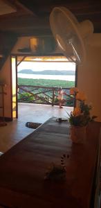 a woman standing in front of a window with flowers on a table at villa nosy détente in Nosy Be