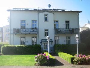 a large white house with flowers in front of it at Villa Baroni BF nur 200m vom Ostseestrand entfernt in Bansin