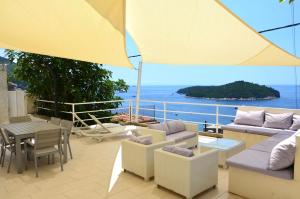 un patio con mesa, sillas y sombrilla en Apartment Chic Ploce, en Dubrovnik