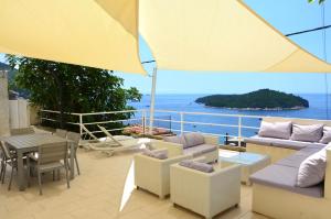 a patio with a table and chairs and an umbrella at Apartment Chic Ploce in Dubrovnik