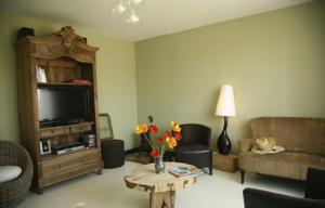 sala de estar con sofá y mesa con flores en Le Mas Capel en Salles-Curan
