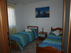een slaapkamer met 2 bedden en een spiegel bij Sardegnadream in San Teodoro