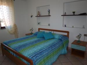 Un dormitorio con una cama con almohadas azules. en Sardegnadream, en San Teodoro