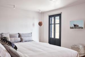 Habitación blanca con cama y ventana en Periscope Suite Private Jacuzzi en Drafaki
