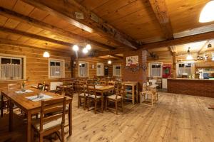 a restaurant with wooden floors and tables and chairs at Chata Rychtářka in Janov nad Nisou