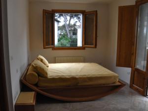 a large bed in a room with a window at Appartamenti fronte mare in Castiglioncello
