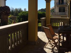 a porch with a chair and a table on a balcony at Appartamenti fronte mare in Castiglioncello