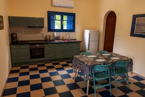 a kitchen with a table and chairs and a refrigerator at Theo's house in Chora! in Andros