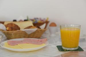 a glass of orange juice next to a plate of bread at Trianta Hotel Apartments in Ialysos