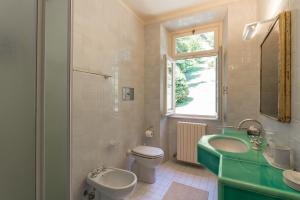un bagno con un lavandino verde e un water di Apartment Anna - Griante a Griante Cadenabbia Altre 25 foto