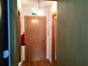 a hallway with a wooden door and a fire extinguisher at La Barquera in Ribadesella