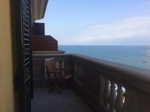 a balcony with a chair looking out at the ocean at Appartamenti fronte mare in Castiglioncello