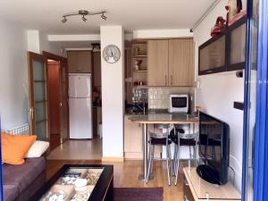 a kitchen and living room with a table and a couch at La Barquera in Ribadesella