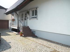 ein weißes Haus mit einer Treppe und einer Tür in der Unterkunft Haus am See in Rust