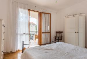 um quarto com uma cama e uma grande janela em Casa Bea Bosa/Magomadas em Magomadas