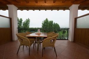 バルドリーノにあるLocanda Ristorante al Cardellinoの木製テーブルと椅子付きのバルコニーから眺めの良い景色を楽しめます。