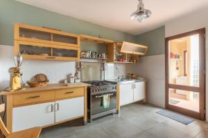 uma cozinha com armários brancos e um forno com placa de fogão em Casa Bea Bosa/Magomadas em Magomadas