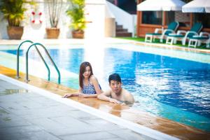a man and a woman laying in a swimming pool at The Empress Hotel - SHA Extra Plus in Chiang Mai