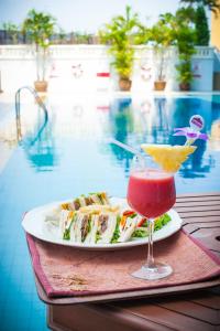 a plate of sushi and a drink next to a pool at The Empress Hotel - SHA Extra Plus in Chiang Mai