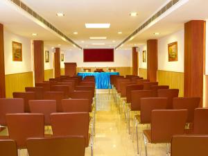 uma sala de conferências com cadeiras e um pódio em Hotel Aiswarya em Cochin