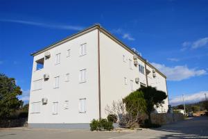 a white building with windows on the side of it at Apartment Noel in Novalja