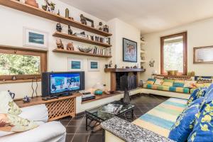 sala de estar con sofá y TV en Villa Gilda - Griante, en Cadenabbia