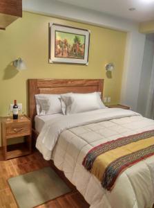 a bedroom with two beds and a picture on the wall at Picos House MachuPicchu in Machu Picchu