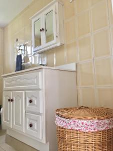 a bathroom with a white cabinet and a basket at Bubali Gardens in Palm-Eagle Beach