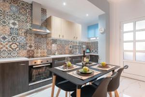 a kitchen with a table and chairs and a fireplace at Ostria Apartments in Kalamaki